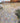 Paved patio area with a mix of large and small stone tiles, surrounded by garden plants.