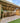 Wooden pergola structure in a backyard with patio and grass area.