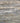 Pattern of stacked stone tiles with varying shades of gray and brown.