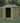 Wooden shed with a green roof, containing a lawnmower, surrounded by trees and a fence.