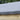 Close-up of a gray roof membrane on a wooden surface with greenery in the background