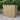 Wooden garden shed on a patio with greenery in the background