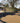 Residential driveway with black geotextile fabric and gravel, house in the background