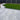 Patio area with gray tiles and a curved artificial grass lawn.