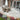 Outdoor garden paving patio area with wicker furniture, umbrella, and sliding glass door.