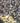 A dense pile of smooth river pebbles and stones in mixed natural colors including gray, beige, brown, and muted orange, filling the entire frame.
