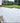 Paved patio area with a grassy lawn and garden in the background