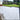Paved patio area with a grassy lawn and garden in the background
