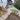 Garden with gravel path, wooden steps, and artificial grass patch near a modern house.