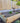 Wooden raised garden bed with plants against a wooden fence