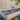 Wooden raised garden bed with plants against a wooden fence