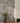 Gray stone wall with a vase of flowers and a white fireplace.