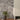 Gray stone wall with a vase of flowers and a white fireplace.