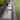 Garden pathway made of wooden planks on a gravel bed, surrounded by greenery.