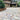 Brick patio in front of a house with a person walking towards it