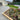 Garden with a paved patio area and landscaped garden bed with plants and flowers.