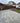 Gray tiled patio area in a residential backyard with a house in the background.