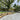 Outdoor patio area with wooden planters, paved walkway, and trees