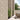 Outdoor patio area with stone wall, potted plants, and wicker furniture.