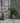Modern outdoor setting with a stone wall, plants, and a glass door.