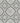 Gray and white repeating decorative tile pattern with ornate scrollwork and floral motifs.