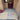 A set of decorative outdoor paving tiles with a gray and white geometric pattern, arranged on a brick doorstep pathway alongside gravel beds and a front door.