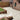 Paved patio area with brick border and grass patch next to a brick building.