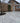 Gray porcelain stone tiles patio in front of a brick house
