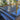 Woodland Anthracite Porcelain Paving Planks; glossy dark grey, black wood effect, natural style paving slabs for patio area, with wooden sleeper beds and mulch borders