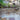 Stone patio with steps leading up to a house with a beige stone wall and garden.